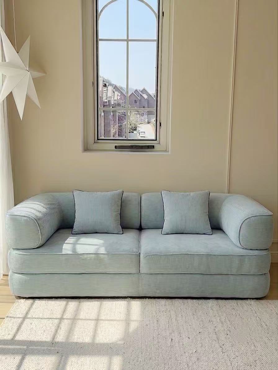 Aura Teddy Sofa Bed in fresh blue styled in a bright living room